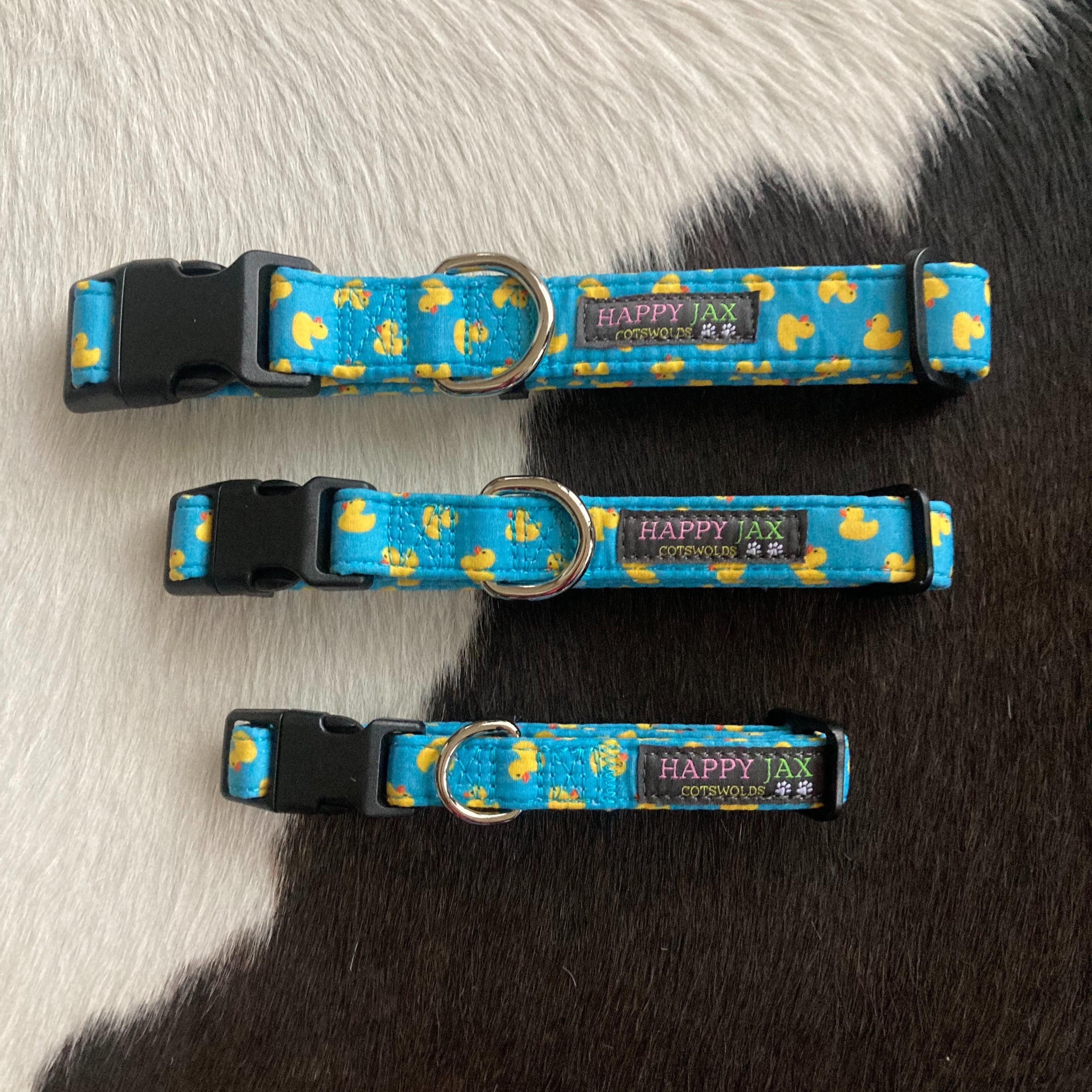 3 animal collars of differing sizes patterned with bright yellow rubber ducks on a sky blue or light blue background