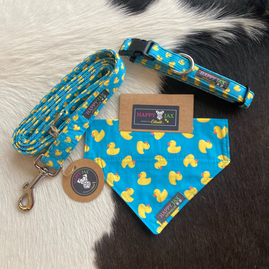 Bundle with an animal collar, bandana and lead in a bright and colourful design of yellow rubber ducks on a sky blue background . Products are suitable for both cats and dogs and available in a range of sizes, made with cotton and designed in the Cotswolds.