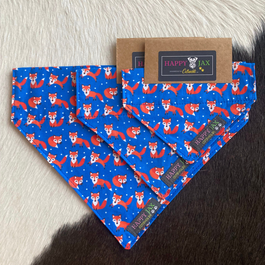 3 different sizes of bandanas with bright orange foxes playing on a navy blue background